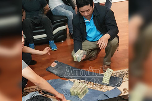 Những cọc tiền còn nguyên tem niêm phong của ngân hàng được cuốn trong hai chiếc quần bò