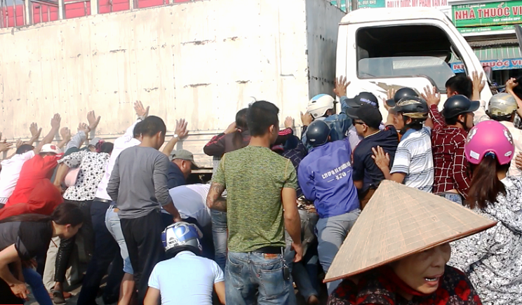 Hàng chục người dân khiêng xe tải cứu 2 người bị cuốn dưới gầm ảnh 1 Hàng chục người dân khiêng xe tải cứu 2 người bị cuốn dưới gầm ảnh 1