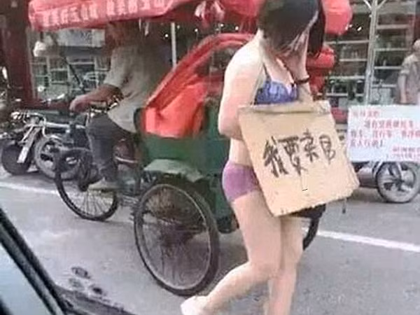 Bắt vợ đeo biển "bán thân" giữa phố vì tội ngoại tình ảnh 1