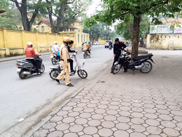 Bắt đầu xử phạt học sinh ngồi trên xe đạp điện, xe máy không đội mũ bảo hiểm ảnh 1