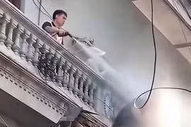 Người đàn ông liên tục xịt nước vào thợ đang tháo dỡ công trình