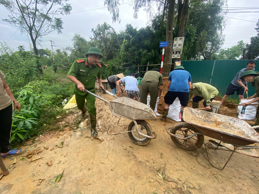 Lực lượng Công an xã cùng người dân khẩn trương đắp đê ngăn lũ