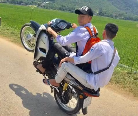 Hai nam thanh niên điều khiển xe máy bằng một bánh