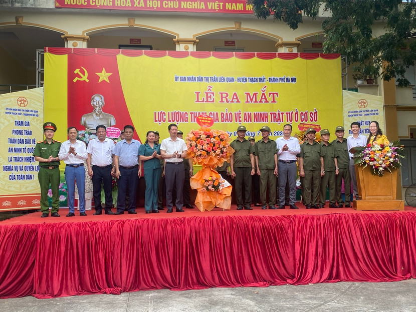 Đại diện lãnh đạo thị trấn Liên Quan tặng hoa chúc mừng các tổ bảo vệ ANTT ở cơ sở