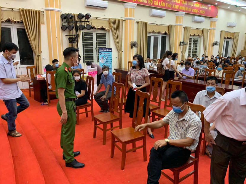 Cán bộ Công an xã Kim Quan thường xuyên nhắc nhở người dân ngồi giãn cách, đeo khẩu trang