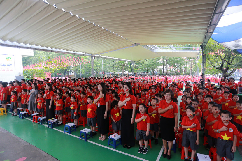 Hàng trăm học sinh cùng các thầy cô giáo mặc áo cờ đỏ sao vàng cùng nhau hát Quốc ca tạo nên khoảnh khắc thiêng liêng đầy xúc động