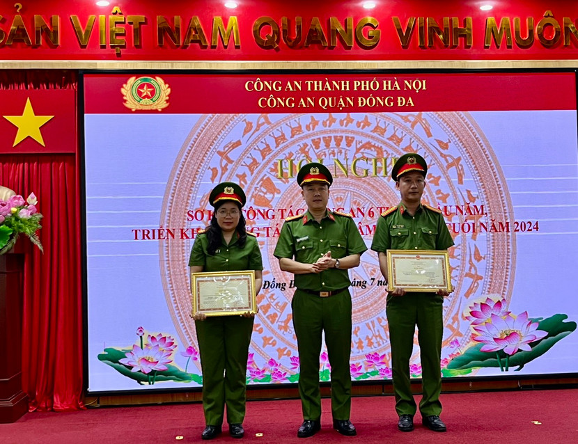 Đại tá Nguyễn Đức Long - Trưởng Công an quận Đống Đa trao khen thưởng của Bộ Công an cho Trung tá Nguyễn Thành - cán bộ Công an phường Kim Liên và Thiếu tá Bùi Thị Hạnh - Đội phó Đội Cảnh sát điều tra tội phạm về ma túy