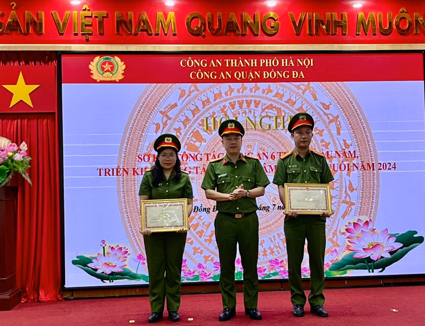 Đại tá Nguyễn Đức Long - Trưởng Công an quận Đống Đa trao khen thưởng của Bộ Công an cho Trung tá Nguyễn Thành - cán bộ Công an phường Kim Liên và Thiếu tá Bùi Thị Hạnh - Đội phó Đội Cảnh sát điều tra tội phạm về ma túy