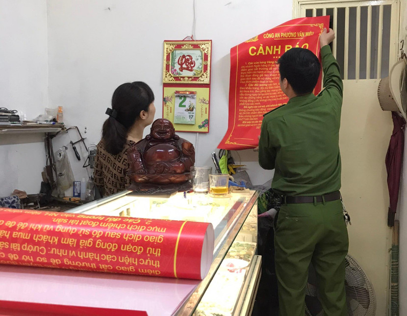 Lực lượng Công an dán thông báo tại các cửa hàng vàng