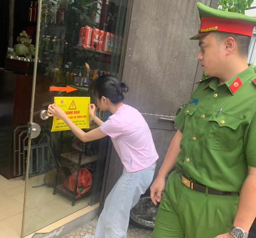 Công an phường Ô Chợ Dừa cùng nhân dân dán thông báo phòng ngừa tội phạm