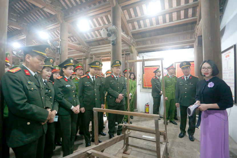 Các cán bộ, chiến sĩ xúc động khi nghe thuyết minh viên giới thiệu về chiếc khung cửi mà bà Hoàng Thị Loan đã dệt vải được chế tác theo nguyên mẫu chiếc khung cửi đang trưng bày ở huyện Nam Đàn (Nghệ An)