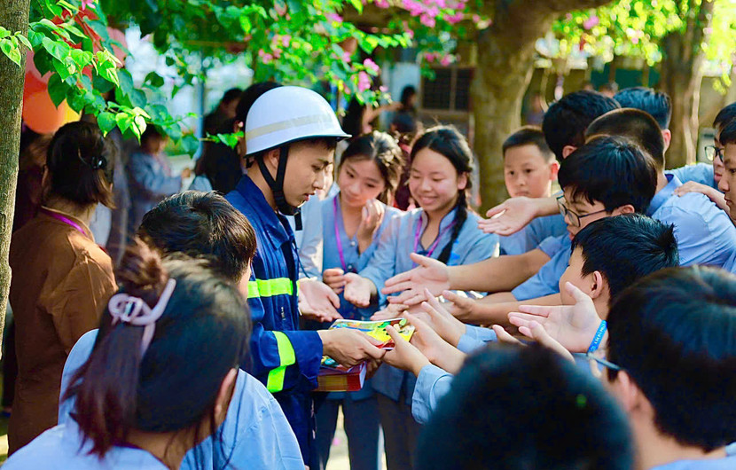 Tuyên truyền viên phát nhiều tờ rơi, sổ tay trong công tác PCCC&amp;CNCH tới học viên.