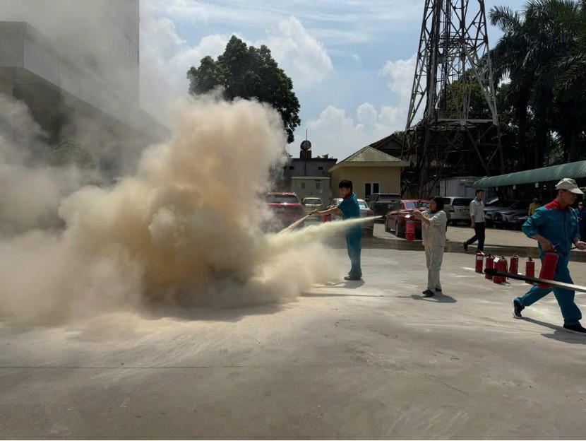 Các công nhân được hướng dẫn sử dụng bình chữa cháy xách tay để khống chế đám cháy