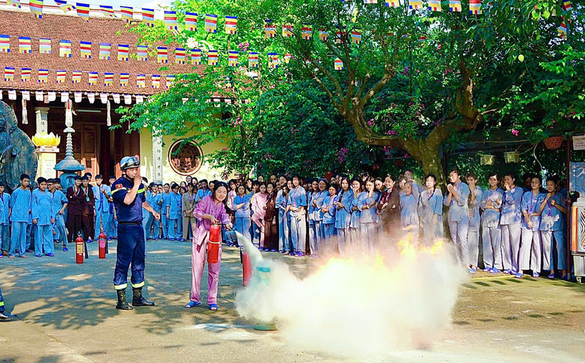 Tuyên truyền viên hướng dẫn các tu sinh kỹ năng sử dụng bình chữa cháy xách tay chữa đám cháy khi gas.