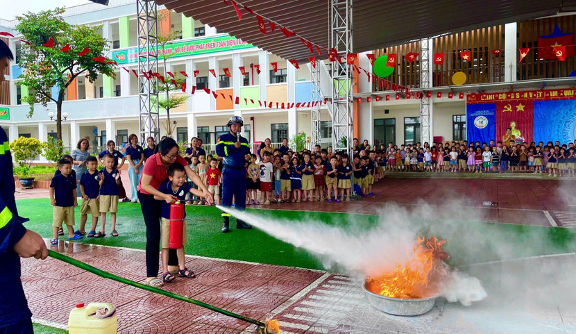 Cán bộ, giáo viên và học sinh trải nghiệm sử dụng bình chữa cháy xách tay chữa đám cháy xăng dầu, khí gas.