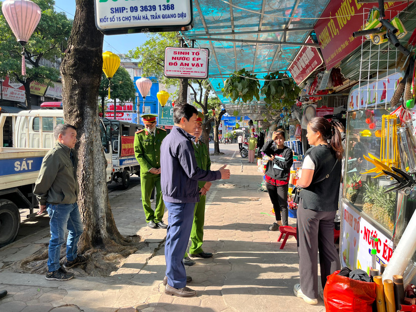 Phó Chủ tịch UBND quận Đống Đa - Hà Anh Tuấn trao đổi với nhân dân, các hộ kinh doanh ở khu vực chợ Thái Hà