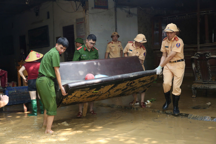 Các lực lượng Công an Thủ đô phối hợp cùng người dân đưa những vật dụng nặng, bị ngâm trong nước lũ ra ngoài để xử lý, dọn dẹp, từng bước trả lại không gian sinh hoạt cho các hộ gia đình