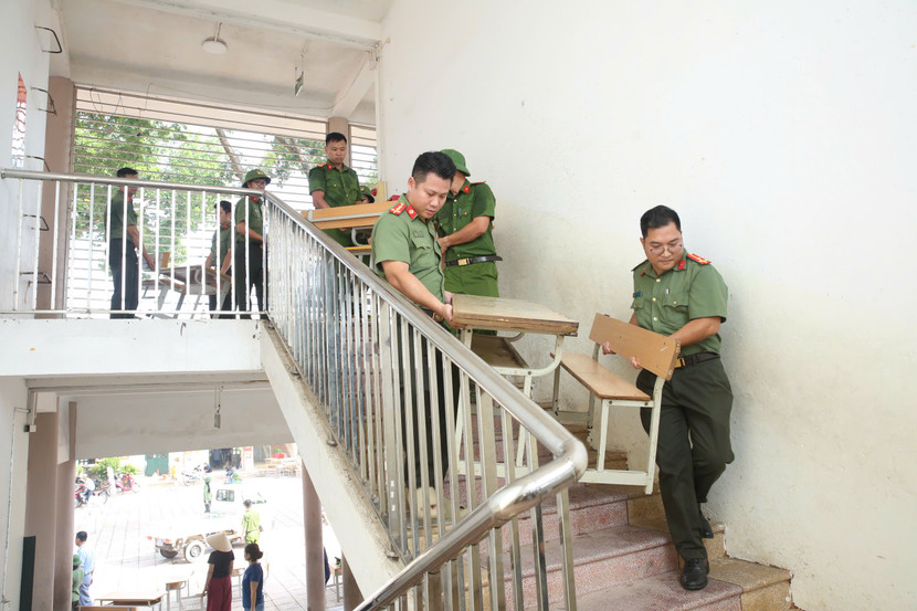 Tại Trường Tiểu học Trung Giã A, một trong những địa điểm bị ngập nặng, các cán bộ, chiến sĩ khẩn trương di chuyển bàn ghế, trang thiết bị dạy học để vệ sinh, sửa chữa, chuẩn bị cho ngày học sinh trở lại