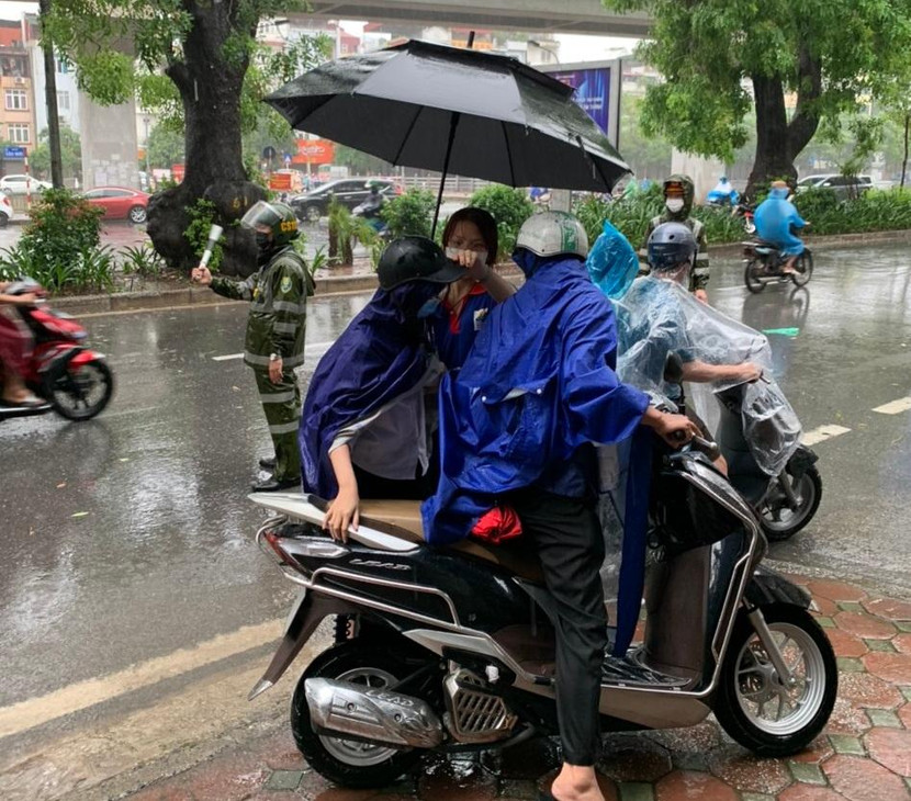 Các tình nguyện viên, đoàn viên thanh niên hỗ trợ các em học sinh di chuyển vào điểm thi để không bị ướt Các tình nguyện viên, đoàn viên thanh niên hỗ trợ các em học sinh di chuyển vào điểm thi để không bị ướt