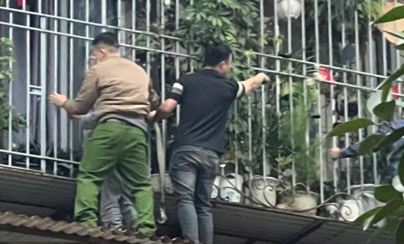 Cán bộ Công an phường đưa cụ ông xuống an toàn
