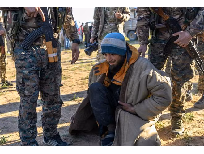 Binh sĩ SDF kiểm tra tay súng IS trước khi tiến hành di tản