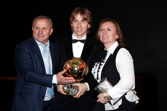 Modric nở nụ cười hạnh phúc chụp ảnh cùng với cha mẹ.