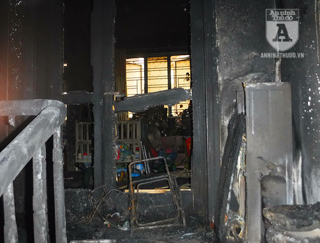 Đầu cầu thang tầng 3, cửa ra vào phòng bị thiêu cháy, trước cửa là một chiếc ghế bị cháy còn trơ khung