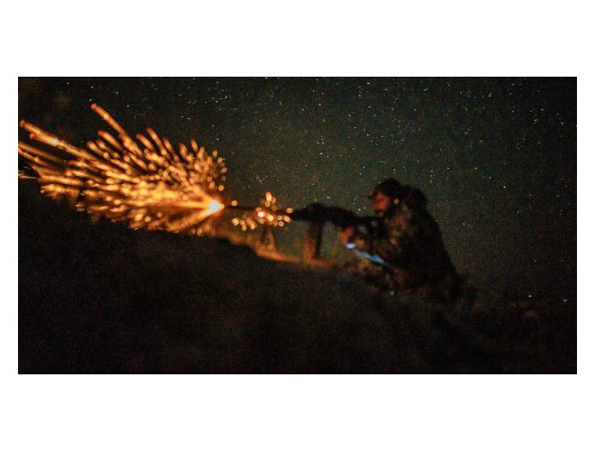 Khói bốc lên từ những tòa nhà đáng cháy, ánh sáng ánh cam bởi ngon lửa và đám cháy giữa những tiếng súng nổ liên tục