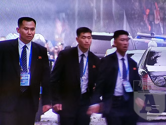 Các cảnh vệ tiếp cận Chủ tịch Triều Tiên chạy bộ ra xe khi Chủ tịch Kim Jong - un chuẩn bị di chuyển. Những cảnh vệ này là những công dân Triều Tiên duy nhất được phép mang súng khi đi bên cạnh nhà lãnh đạo