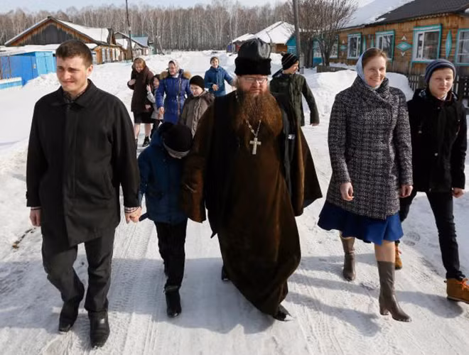 Linh mục Sergei Ryzhov (giữa) và các thành viên gia đình đi bộ tới điểm bỏ phiếu ở ngôi làng thuộc vùng Siberia