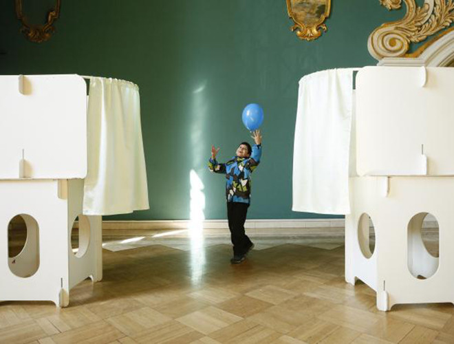 Em bé chơi đùa với trái bóng gần điểm bỏ phiếu ở thủ đô Moscow