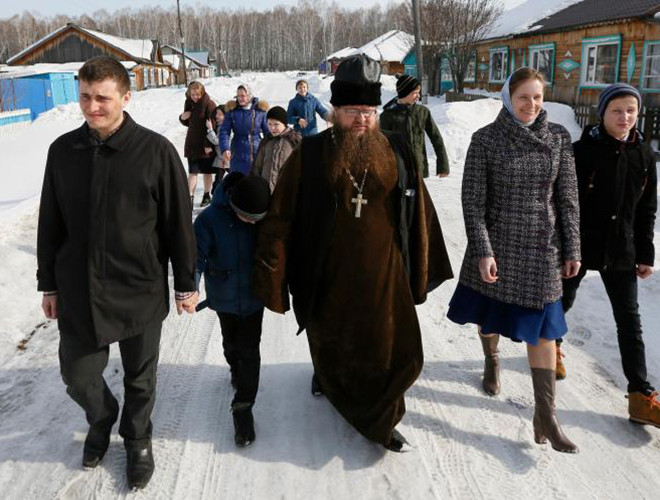 Linh mục Sergei Ryzhov (giữa) và các thành viên gia đình đi bộ tới điểm bỏ phiếu ở ngôi làng thuộc vùng Siberia