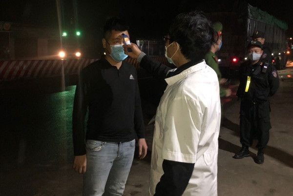 Tổ công tác của Đội CSGT số 11, Phòng CSGT hỗ trợ lực lượng y tế đo thân nhiệt của các lái xe ở cao tốc Hà Nội - Hòa Bình