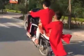 Hai thanh niên 'diện' áo dài đỏ 'bốc đầu' xe máy