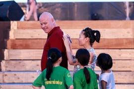 Thu Minh mượn lưng chồng để kê giấy, ký tên tặng khán giả nhí