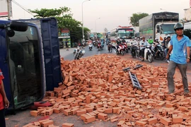 Xe tải bất ngờ “trút” gạch xuống giữa QL1A