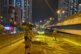 Cảnh sát giao thông rải cát dọn vết dầu loang trên đường dẫn vành đai 3