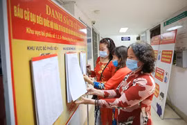 Thủ đô Hà Nội đang tập trung cao độ để thực hiện mục tiêu kép, vừa bảo đảm an toàn, bình yên cho nhân dân, vừa bảo đảm thành công ngày bầu cử (Trong ảnh: Người dân theo dõi danh sách niêm yết cử tri tại trụ sở HĐND, UBND phường Hàng Đào, quận Hoàn Kiếm, Hà Nội). Ảnh: LAM THANH