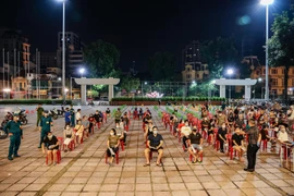 Người dân xếp hàng chờ tiêm vaccine vào buổi tối (ảnh chụp tại điểm tiêm chủng tổ chức ở Cung Văn hoá Hữu nghị Việt - Xô thuộc phường Trần Hưng Đạo, quận Hoàn Kiếm, Hà Nội)