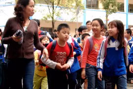 Học sinh Hà Nội đi học trở lại sau một ngày nghỉ tránh bão