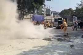 Cảnh sát giao thông hỗ trợ người dân dập tắt đám cháy trong bãi trông giữ xe ô tô