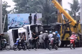 Container lật nhào, người dân đập kính cứu tài xế mắc kẹt