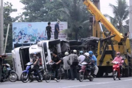 Container lật nhào, người dân đập kính cứu tài xế mắc kẹt