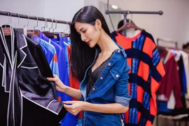 Hoàng Thuỳ kéo vai áo trễ nải khi đi thử đồ