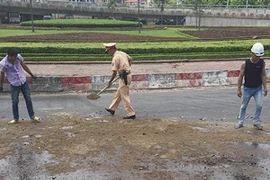 Cảnh sát giao thông dọn dầu loang trên đường 