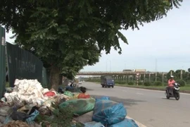 Rác, vật liệu xây dựng "bao vây" đại lộ Thăng Long