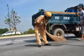 CSGT quét dọn đá rơi vương vãi khắp mặt đường giữa trưa