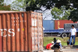Thùng container chở gạo văng xuống đường, dân giúp tài xế giữ hiện trường