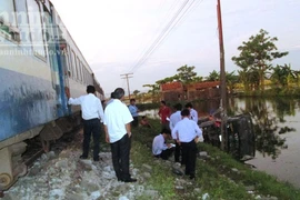 Chết máy, xe tải bị tàu Thống Nhất húc bay xuống ao