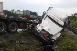 Xe tải chở cát "húc" xe container xuống cống thoát nước bên đường